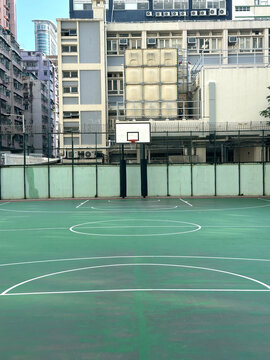 Urban basketball court with buildings in the background on a clear day