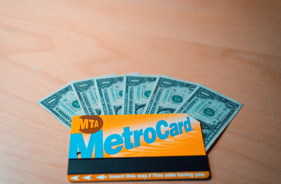 Barcelona, Spain. June 28, 2026, MTA MetroCard becoming a collector's item in New York City with one dollar bills fanned behind it