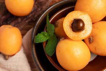 Fresh Loquats in Bowl with Mint Leaves © NguyenNhat