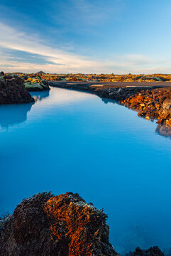 Volcanic lava formations beside the Blue Lagoon in Iceland with vivid moss colorful geothermal landscape and crystal blue water