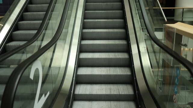 Escalator smoothly moves upward inside modern building creating clean architectural scene with urban transportation and contemporary interior