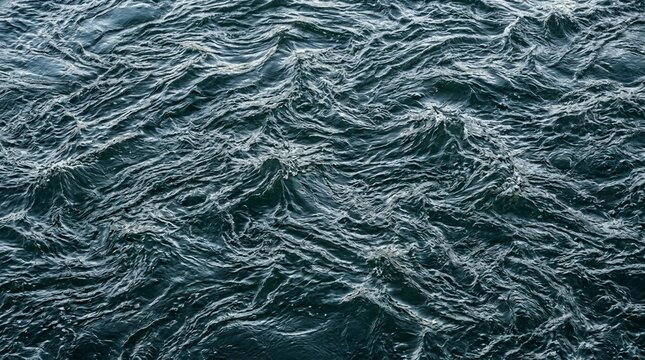 Rough dark ocean water surface with deep blue-green hues and intricate ripples creating a dynamic liquid texture