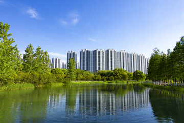 High-rise apartment towers by a lakeside park © DinhBaoTran