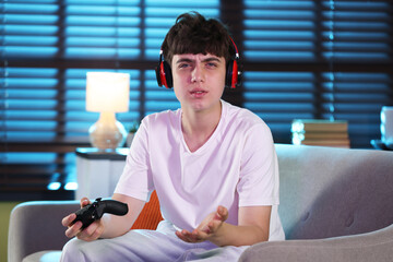 Teenage boy playing video game at home © New Africa