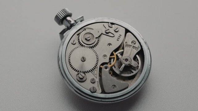 Detailed internal gears and oscillating balance wheel of a vintage mechanical stopwatch. Concept of precision engineering, time management, complex mechanics, and classic horology
