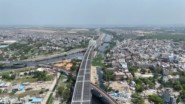 Aerial drone view of Delhi Mumbai Expressway corridor and Delhi Metro near Kalindi Kunj, Delhi India