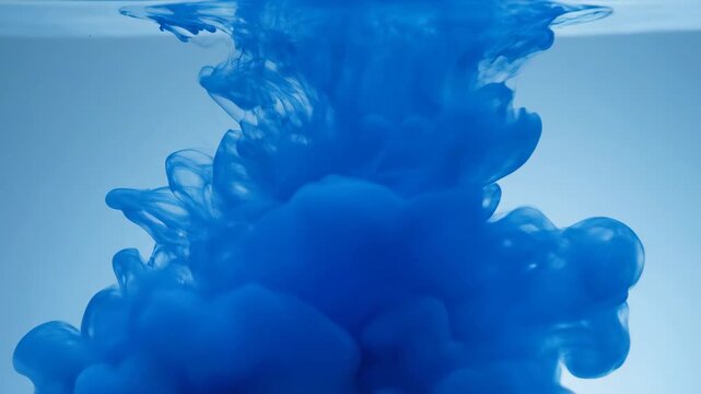 Blue Ink Droplet Dissolving In Clear Water Creating Abstract Swirling Smoke Patterns On Light Background High Quality Fluid Dynamics Concept