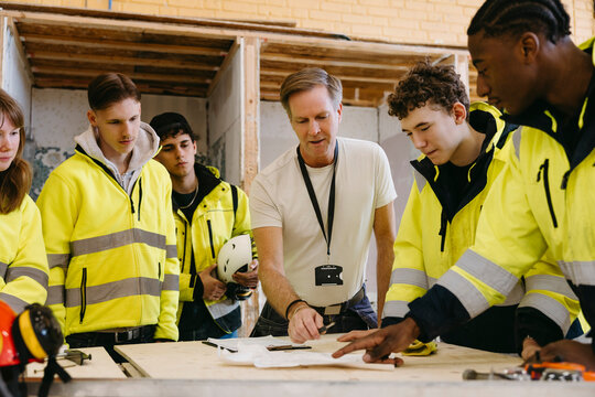 Male vocational instructor teaching students at training session in workshop
