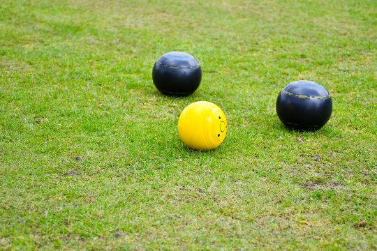Crown green bowling balls black balls placed around the yellow target ball. A popular sport played individually and as part of a team.