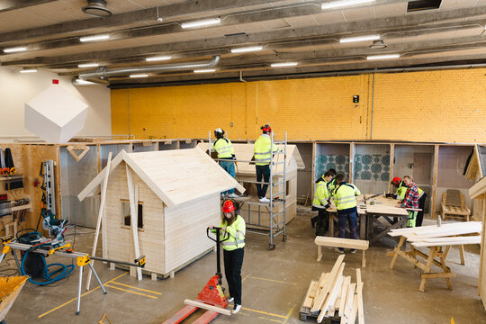 High angle view of vocational students doing carpentry tasks in workshop at upper secondary school