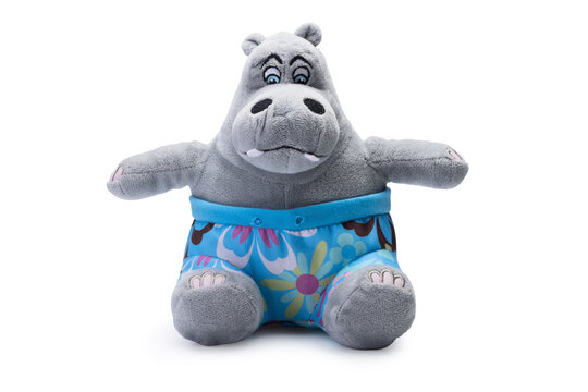 Cute plush hippo toy wearing colorful floral swim shorts isolated on white background