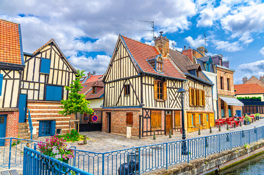 Traditional fachwerk houses old buildings on embankment promenade of Somme river water canal in Saint-Leu quarter in Amiens historical city centre, Hauts-de-France Region, Northern France