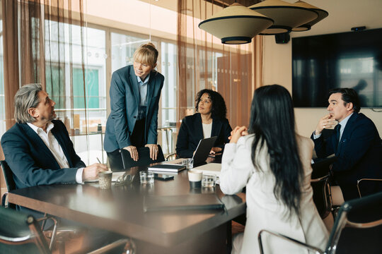White collar workers sharing ideas with each other during meeting in office board room