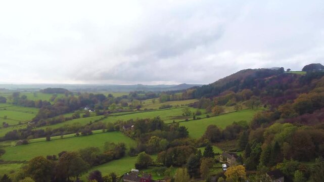 Drone video showing Peak District's Baslow Edge hills with steep cliff like edges, drone coming towards the edge showing it closer and closer.