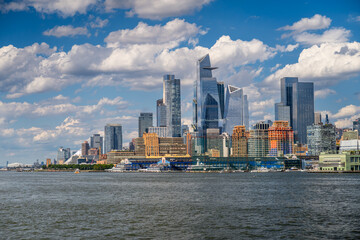 Fototapeta premium Hudson Yards and Chelsea skyline under dramatic clouds. Hudson Yards, Vessel, and Chelsea buildings along Hudson River waterfront