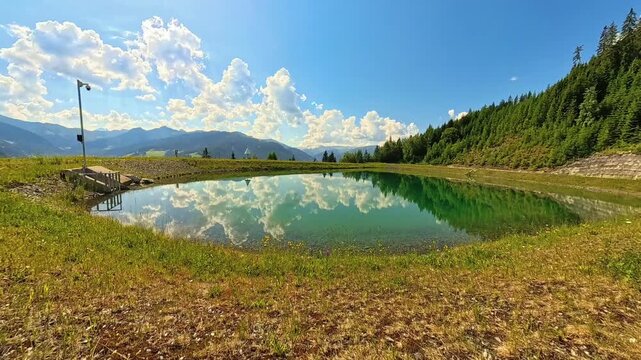 4K Timelapse alpine summer video with moving clouds and reflections at a pond near Grossarl, St. Johann im Pongau, Salzburg, Austria