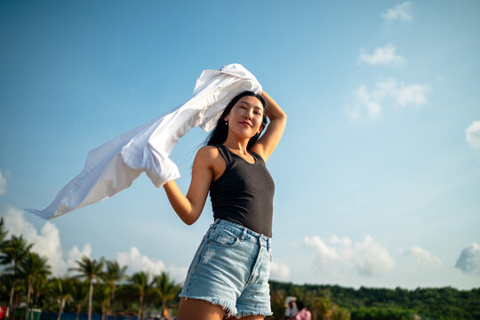 Trendy young traveler enjoying sunny weather and coastal breeze on a luxury tropical island resort