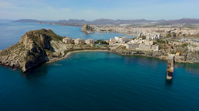 Aerial view of Aguilas city in Murcia, Spain, featuring Levante Bay and marina. Coastal urban landscape with calm Mediterranean waters, harbor structures and scenic shoreline.