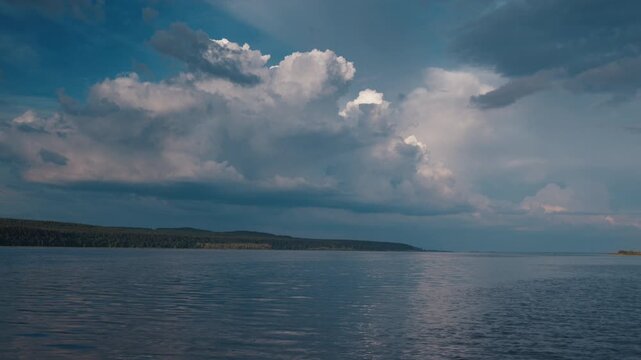 Cumulus clouds over the river during calm summer day