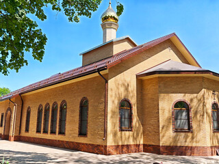 Fototapeta premium St. Michael's Athos Monastery located in Adygea, Russia, showcases its architectural design and structure under the bright sky in a peaceful setting during daylight hours