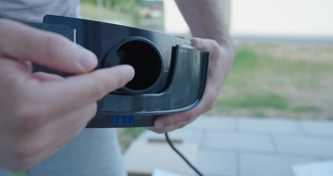 person showing and adjusting the inlet connection on a swimming pool pump. Maintenance concept of pool equipment, water circulation, installation, and pump servicing.