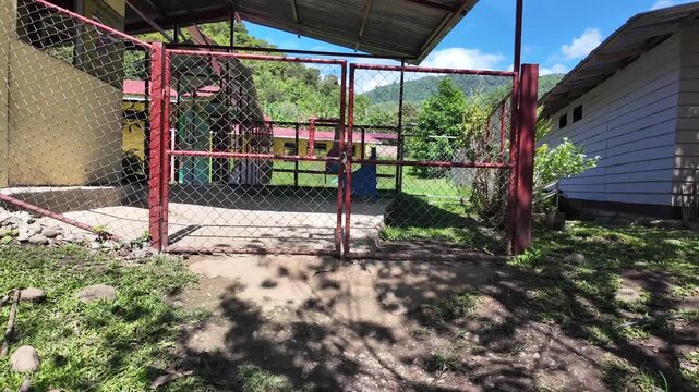 Approaching a rural schoolyard gate in a mountain village