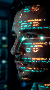 Male programmer face illuminated by projected glowing code in dark data center