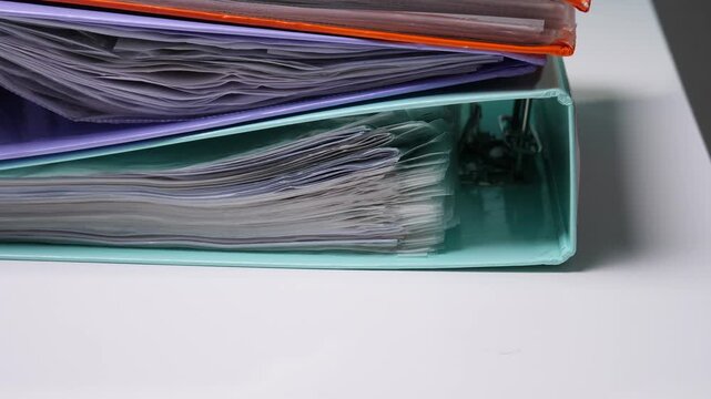 Stacked ring binders, filled with numerous documents, folders, and paper, creating an organized archive of essential information for administrative tasks and office work