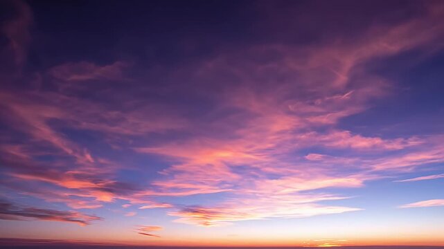 Vibrant purple and orange sunset sky with wispy clouds.