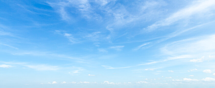 Beautiful clear blue sky background with soft white clouds and empty copy space for panoramic summer travel mockup design