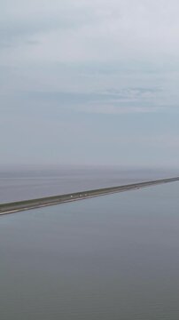 Aerial view of cars traveling on the afsluitdijk causeway