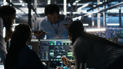Fototapeta premium Data center colleagues use node tree software together to analyze datasets and optimize system health.