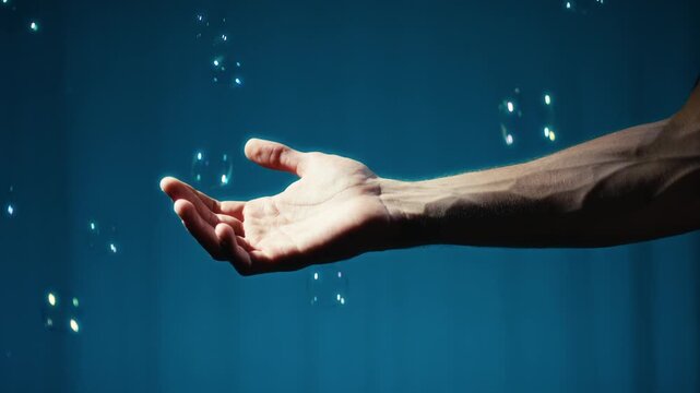 Outstretched hand reaching through soap bubbles
