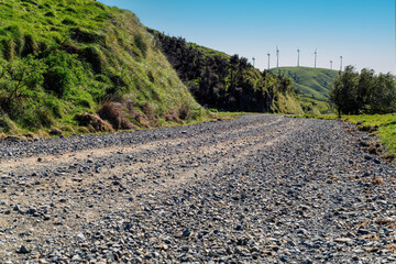 Car background, automotive backplate, gravel country road with wind turbines in the background © Chris