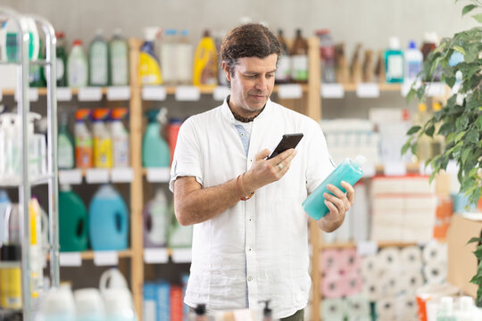 Man customer scans qr code on shampoo or shower gel label. Customer follows link and reads information about product, data on recycling of packaging