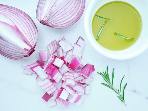Flatlay of chopped red onions and olive oil.