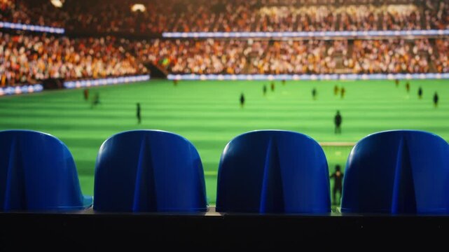 Close up of stadium seating facing blurred soccer field with players waiting for ball kickoff during match day for sports venue and match background content.