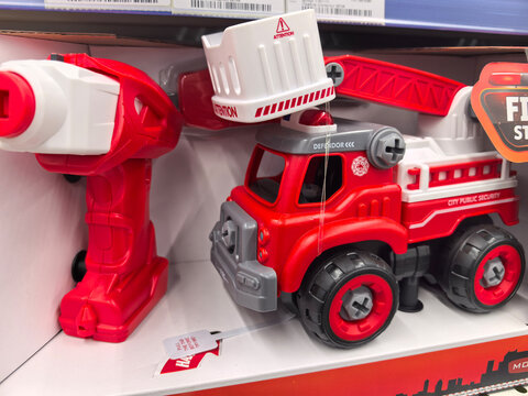 Bright red toy fire truck with an extendable ladder and water nozzle