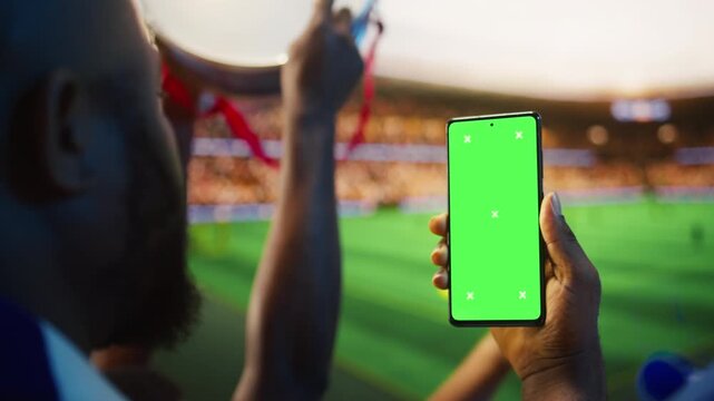 Isolated screen smartphone used by man in stadium tribunes checking other cup match results, showing soccer fan reads live score on chroma key mobile phone from sports venue grandstands, closeup.