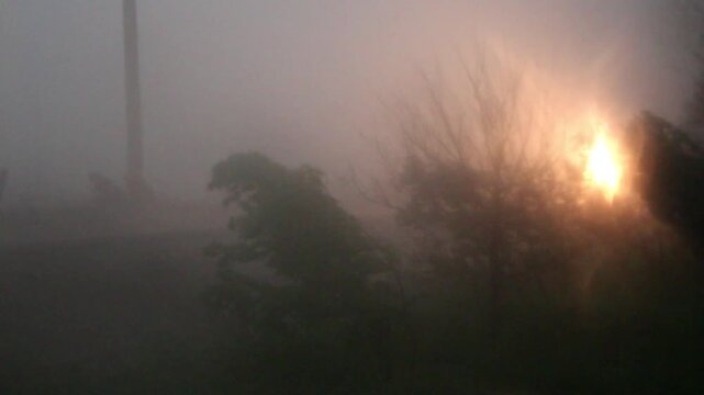 A train passes though a powerful storm with strong wind and rain.