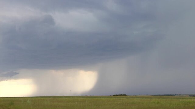 A supercell thunderstorm gathers strength and rains heavily on the plains. Time lapse footage.