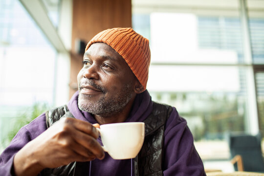 Smiling mature man drinking coffee in cafe