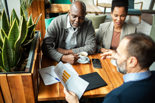 Mature couple meeting financial advisor in cafe