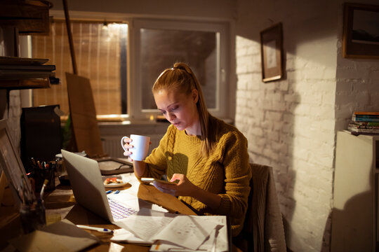Young woman working late at home office with laptop
