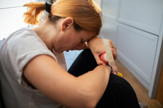 Stressed woman holding pregnancy test at home