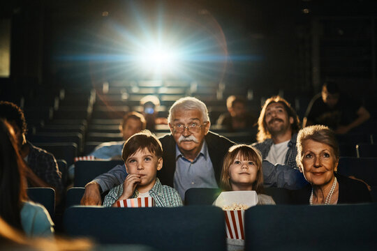 Grandparents and grandchildren watching movie at cinema