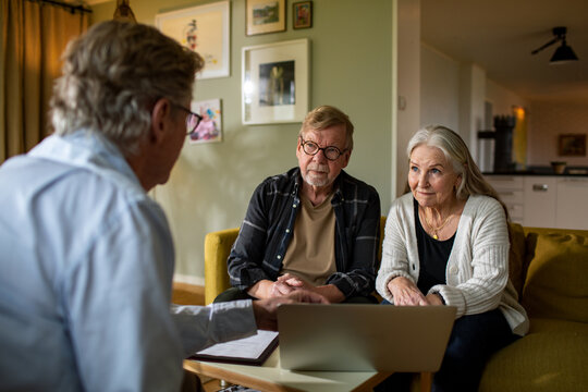 Senior couple meeting financial advisor at home