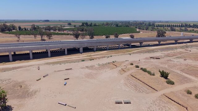Descending and Panning Aerial Drone Shot Right to Left Over California High Speed Rail Construction With Overpass and Farmland
