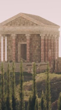 A stone temple sits on a hilltop surrounded by trees. The structure has columns and steps. The sky shows light colors as the sun sets in the background, giving a warm glow to the scene.