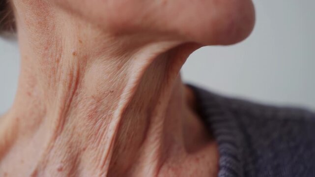 Close-up of the neck and chest of an older person, showing skin texture and wrinkles